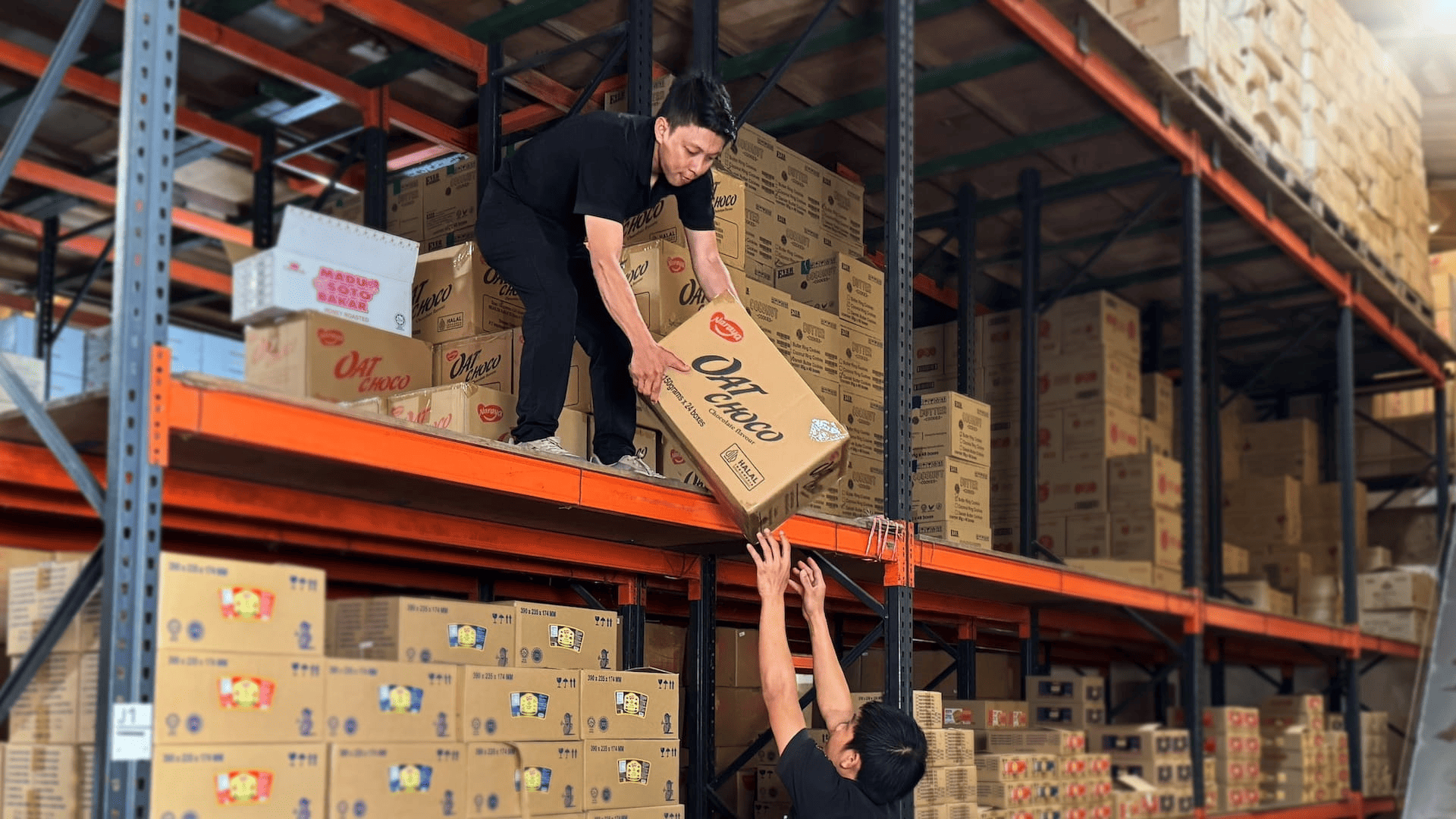 Petugas gudang menyerahkan kardus produk di rak distribusi Mas Food